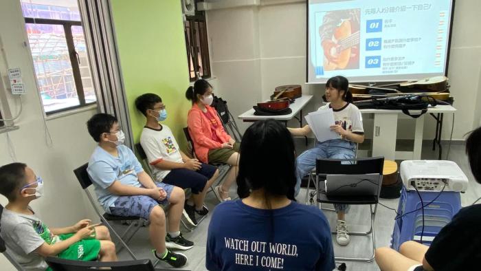 civic fellow holding guitar workshop for children